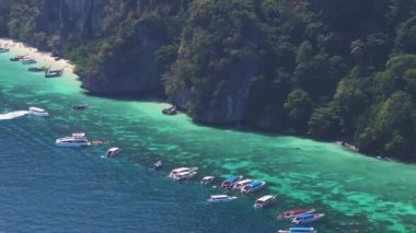 Tayland 'daki Phi Phi Adası' nın havadan görünüşü, turkuaz sular, yemyeşil kayalıklar ve kıyı şeridine demir atmış tekneler..