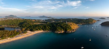 Tayland 'ın Phuket kentindeki Naiharn Sahili' nin havadan görünüşü, altın kum, yemyeşil yemyeşil, demirlemiş tekneler, sakin mavi sular ve ufukta küçük adalar..