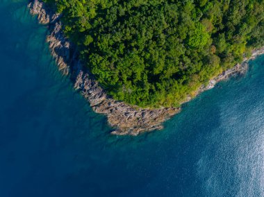 Phuket ya da Phi Adaları 'ndaki canlı mavi sularla çevrili kayalık bir yarımadadaki yemyeşil orman kıyı şeridinin hava perspektifi..