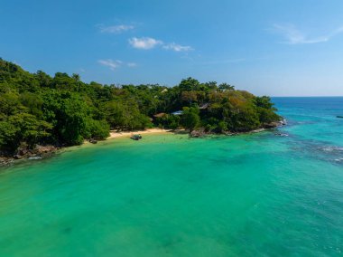 Turkuaz suları, yoğun yeşil bitki örtüsü ve muhtemelen Phuket veya Phi Phi Adaları, Tayland 'da kumlu bir sahil..