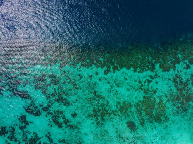 Tayland 'ın Phi Phi Adaları yakınlarındaki canlı bir mercan resifinin havadan perspektifi turkuaz suların derin mavi okyanus derinliklerine geçişidir..