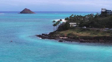 Hawaii, Oahu Adasındaki Lanikai Sahili 'nin havadan görünüşü turkuaz sular, beyaz kum, Mokulua Adaları, yemyeşil yemyeşil ve süzülerek uçan bir kürekçi..