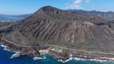 Havadan Oahu, Hawaii manzarası, turkuaz sular, beyaz kumlu plajlar, kayalık kıyı şeridi, yemyeşil ve uzak dağlık arazi.