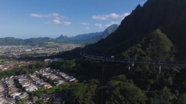 Hawaii, Oahu 'daki yemyeşil dağlar boyunca uzanan, ormanlık alanlar, evler ve Ko olau Dağları boyunca uzanan, yavaş ve geniş bir hava manzarası..