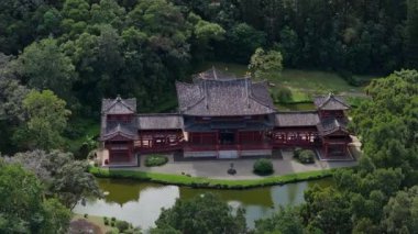 Hawaii, Oahu 'daki Byodo In Temple' ın havadan görünüşü, yemyeşil ve göletle çevrili. Kamera düzgün hareket ediyor, mimarisini vurguluyor..
