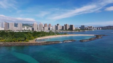 Waikiki Sahili 'nin, Elmas Kafa' nın ve Honolulu 'nun silueti turkuaz sular, dalgalar ve berrak bir gökyüzü altında yemyeşil..