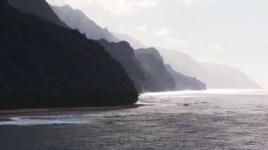 Hawaii, Kauai Adası 'ndaki Napali Sahili' nin havadan görünüşü. Sarp kayalıklar, dalgalı okyanus dalgaları ve engebeli arazi üzerindeki ışık ve gölgeler..