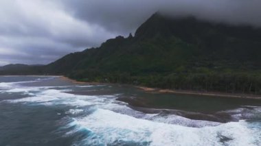 Kauai 'nin gür kıyı şeridinin yavaş bir havası sisli tepeler, canlı ormanlar, kumlu bir sahil ve kıyı şeridi boyunca sığ kayalık sular..