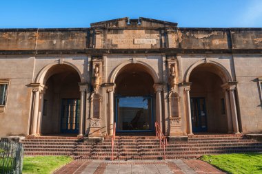 Hawaii 'deki tarihi Albert Spencer Wilcox Memorial Binası kemerli girişler, dekoratif sütunlar, tuğla basamaklar ve küçük çimenli bir alan içeriyor..