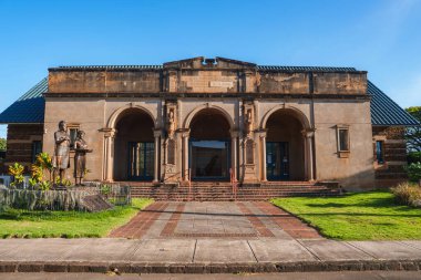 Hawaii, Lihue 'deki Kauai Müzesi' nde üç kemer, süslemeli sütun, bir heykel, tuğla yolları ve açık mavi gökyüzü bulunan klasik bir cephe yer alıyor..