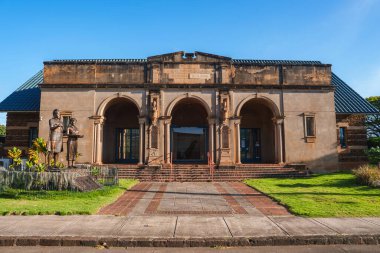 Hawaii, Lihue 'deki Kauai Müzesi' nde üç kemer, süslemeli sütun, bir heykel, tuğla yolları ve açık mavi gökyüzü bulunan klasik bir cephe yer alıyor..