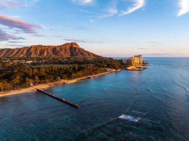 Honolulu, Hawaii 'deki Waikiki Sahili' nin havadan görünüşü. Arka planda elmas başlıklı krater, turkuaz suları, rıhtım ve gün batımında sahile bakan oteller..