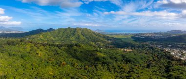 Bereketli yeşil dağlar ve yoğun tropikal bitki örtüsü mavi okyanus, küçük kasabalar, dağınık binalar ve temiz bir gökyüzü olan bir kıyı bölgesine götürür..