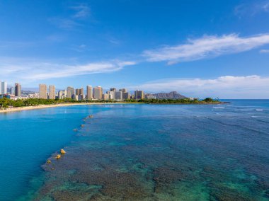 Honolulu, Oahu, Hawaii 'deki Waikiki Sahili' nin havadan görünüşü turkuaz sular, mercan resifleri, Elmas Kafa Krateri ve modern binaların silueti..