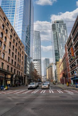 Seattle, ABD şehir merkezinde işlek bir cadde, modern gökdelenler, tarihi tuğla binalar, hafif trafik, yayalar ve ünlü bir Park tabelasının yer aldığı.