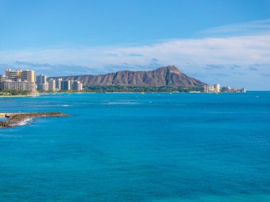 Turkuaz Pasifik suları, Honolulu, Hawaii 'deki berrak mavi gökyüzünün altında Waikiki Sahili kıyılarıyla, yüksek gökdelenli oteller ve Diamond Head Krateri ile buluşur..