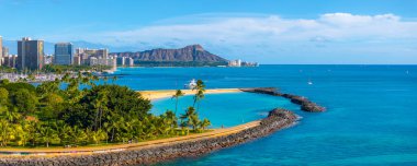 Honolulu, Oahu, Hawaii 'deki Waikiki Sahili' nin havadan görünüşü. Elmas başlı krater, turkuaz sular, kumlu plaj, palmiye ağaçları ve görünür şehir silüeti..