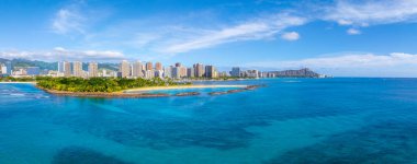 Havadan Honolulu, Hawaii manzarası. Elmas başlıklı krater, turkuaz okyanus, kumlu sahil, yemyeşil park, gökyüzü ve dağınık bulutlar..