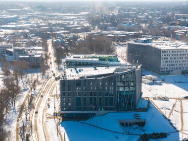 Letonya 'nın Riga kentinin hava görüntüsü, Letonya' nın modern üniversite binasının cam cepheleri, karla kaplı sokakları ve genişleyen şehir manzarasını gözler önüne seriyor..