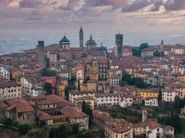 Günbatımında İtalya 'nın Bergamo kentinde Santa Maria Maggiore Bazilikası, Campanone, terracotta çatıları ve kaldırım taşı caddeleri yer almaktadır..