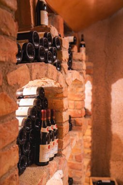 Kırmızı tuğlalı bir şarap mahzeni, düzgün düzenlenmiş şarap şişeleri ve sıcak aydınlatma, muhtemelen Avusturya 'nın Ischgl kentindeki lüks bir işletmenin parçası..