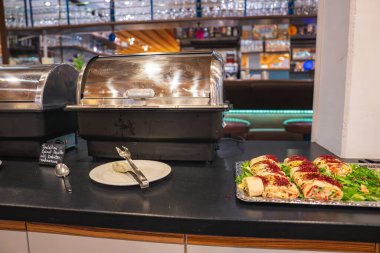 Yemek alanında aşındırıcı yemekler, bir tabak sargı, servis aletleri ve bir dağ tatil köyünde cam eşyalar, sıcak aydınlatma ve modern dekorlarla dolu bir bar yer alıyor..