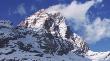 Matterhorn Dağı 'nın İtalyan tarafından havadan görünüşü piramidinin tepeye, sürüklenen bulutlara ve yavaş bir tavaya karla kaplı yamaçlara benzediğini gösteriyor..
