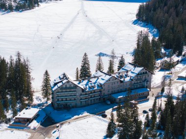 İtalya 'nın Dolomitler kentindeki Braies Gölü karla kaplıydı. Etrafı yemyeşil ormanlarla çevriliydi. Donmuş gölde geniş bir dağ evi ve dağınık figürler görülebilir..