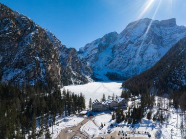 Kış mevsiminde Braies Gölü 'nün havadan görünüşü, karla kaplı tepeler, yemyeşil ağaçlar ve kuzey İtalya' nın donmuş kıyı şeridine yakın bir kulübe ile çevrili..