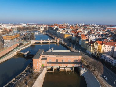 Wroclaw, Polonya 'nın hava manzarası, Oder Nehri' ni gösteriyor, barajı, köprüsü, renkli binaları olan kırmızı tuğlalı bir bina, ve temiz bir gökyüzünün altında kilise kuleleri..
