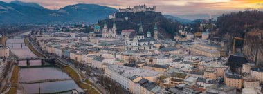 Günbatımında Hohensalzburg Kalesi, Salzach Nehri, tarihi binalar ve kilise kulelerinin yer aldığı Salzburg, Avusturya 'nın hava manzarası.