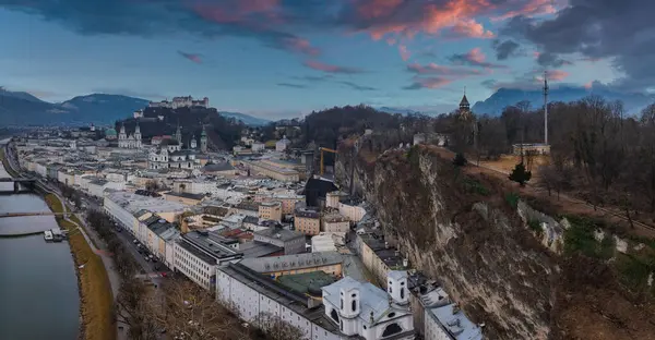Avusturya, Salzburg 'un havadan görünüşü, Hohensalzburg Kalesi' nin bir tepe, Salzach Nehri, tarihi binalar ve canlı bir günbatımı gökyüzü..