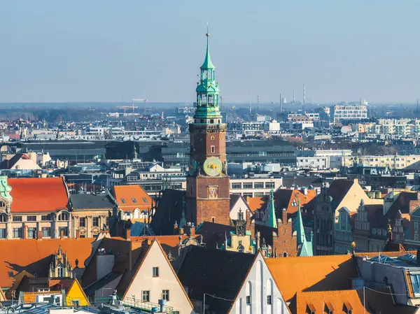 Polonya 'nın Wroclaw kentinin havadan görünüşü, Gotik tarzı, tarihi kırmızı kiremitli binalar ve modern yapılarla çevrili yeşil kulesiyle Eski Şehir Binası Kulesi' ni gösteriyor..