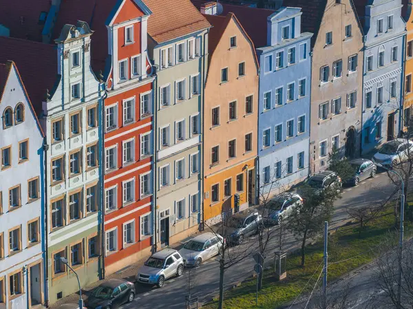 Polonya 'nın Wroclaw şehrinde bir dizi canlı ev dik çatıları, dekoratif gablonları ve ön planda park etmiş arabaları olan ağaç kaplı caddeleri var..