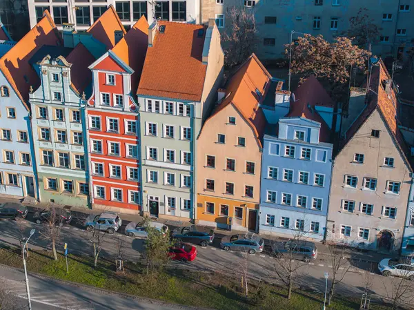 Wroclaw, Polonya 'da mavi, kırmızı, yeşil ve bej ön cepheleri, turuncu kiremitli dik çatıları ve ağaç kaplı caddelerin yer aldığı bir dizi canlı kasaba evi..