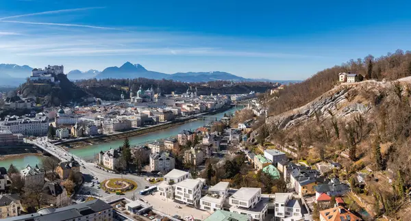 Salzburg, Avusturya 'nın havadan görünüşü, Salzach Nehri, Hohensalzburg Kalesi, tarihi eski kasaba, modern binalar ve uzak dağlar.