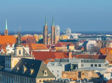 Wroclaw, Polonya 'nın havadan görünüşü, açık mavi gökyüzü altında Gotik Wroclaw Katedrali, kırmızı çatılı Eski Şehir binaları ve modern yapıları vurguluyor..