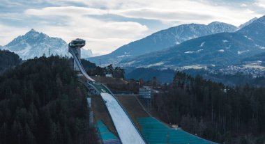 Avusturya 'nın Innsbruck kentindeki Bergisel Kayak Atlayışı, yoğun ormanlar ve dağlık sıradağlarla çevrili modern tasarımı ile bir orman tepesinde duruyor..