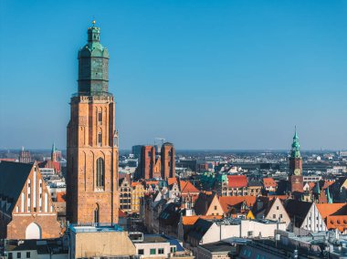 Wroclaw, Polonya 'nın gökyüzü manzarası, yüksek tuğlalı kulesi ile St. Elizabeths Kilisesi' ni ön plana çıkarıyor, renkli tarihi binalar ve kırmızı kiremitli çatılarla çevrili..