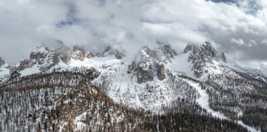 İtalya 'nın Cortina kenti yakınlarındaki Dolomitlerin tepelerini yoğun ormanlar, görünür bir kayak yamacı ve dinamik ışık ve gölge efektleri yaratan bulutlar kapladı..