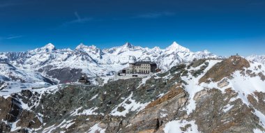 İsviçre 'nin Zermatt kentindeki Gornergrat Gözlemevi' nin hava manzarası. Kayalık bir sırt üzerindeki kubbeli yapılar, karla kaplı tepeler ve Matterhorn 'la çevrili..