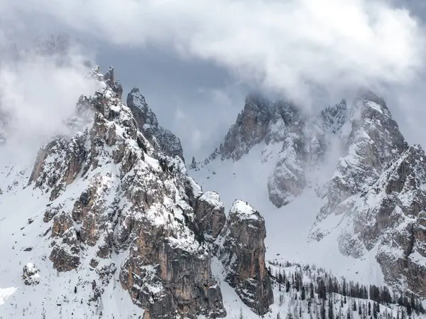 İtalya 'daki Dolomitlerin zirvelerini kaplayan karlar, engebeli arazilerin yakınlarındaki sarp kaya oluşumları, sis, bulut ve seyrek ağaçlara ev sahipliği yapıyordu..