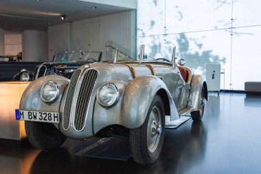 Almanya 'nın Münih kentindeki modern BMW Müzesi' nde dikey böbrek ızgarası ve yuvarlak farlı parlak bir BMW 328 roadster sergileniyor..