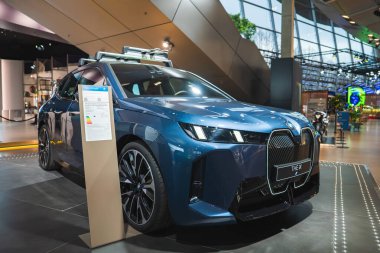 LED farları ve böbrek ızgarası olan parlak mavi bir BMW iX SUV Almanya 'nın Münih kentindeki BMW Müzesi' nde sergileniyor..