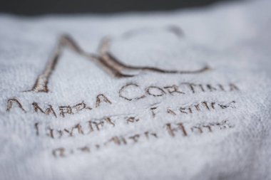 Rafine kahverengi işlemeli beyaz havlu üzerinde AMBRIA CORTINA Lüksü ve Fashion Boutique Oteli, Dolomites, İtalya 'da bir otelle ilişkili..