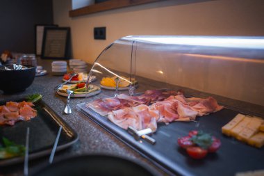 Güney Tyrol, İtalya 'da modern bir otelde sosyetik kahvaltı büfesi, peynir, tütsülenmiş somon ve taze sebzeler..