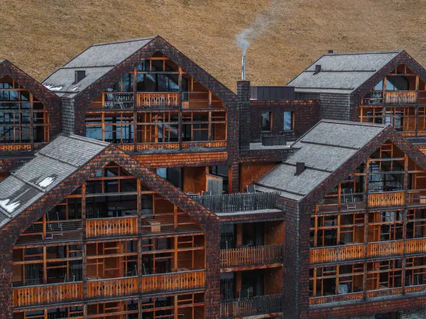 İtalya 'nın Dolomitler kentindeki çorak bir yamaçta kurulu, ahşap balkonları ve taş detayları olan modern Alp tarzı binalar kümesi..