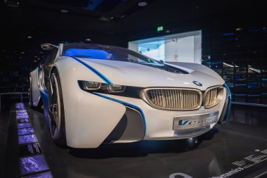 Beyaz bir BMW konsept araba mavi aksanlı ve aerodinamik tasarımı ile Münih, Almanya 'daki BMW Müzeleri yansıtıcı iç mekanında sergilenmektedir..