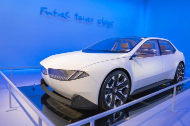Pürüzsüz, beyaz bir BMW konsept araba. Açısal farları ve böbrek ızgarası var. Müzede mavi ışıklandırmayla sergileniyor..