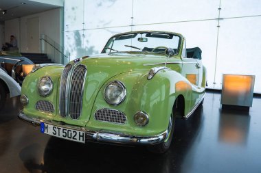 Üstü açık, yuvarlak farları ve krom ızgarası olan klasik bir BMW, Münih 'teki BMW Müzesi' nde sergileniyor..